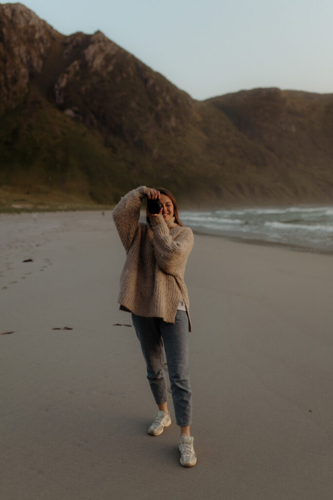 Bild på gravidfotograf Nadia Deland Storm som håller upp en kamera framför ansiktet